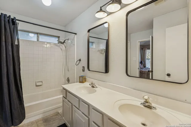 a bathroom with 2 sink tub and a mirror