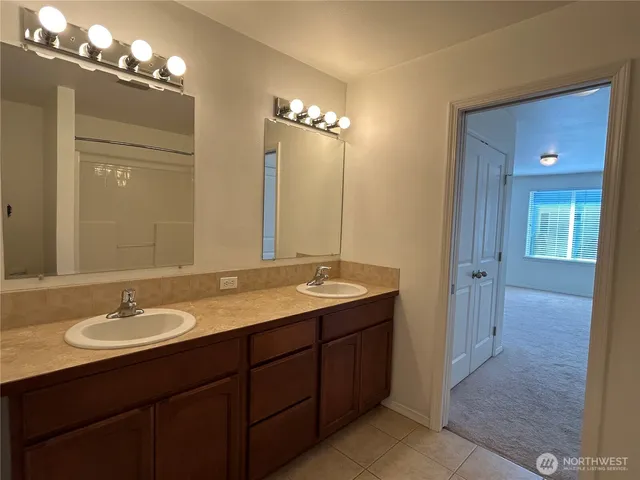 a bathroom with a double vanity sink and a mirror