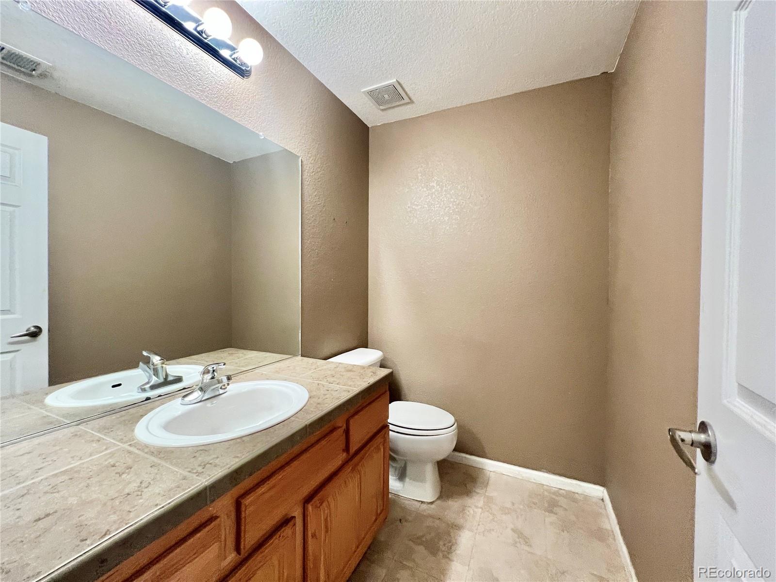 1385 South Chambers Road, Unit 102 Aurora, CO 80017 - Photo 11 of 20 a bathroom with a granite countertop sink and a mirror