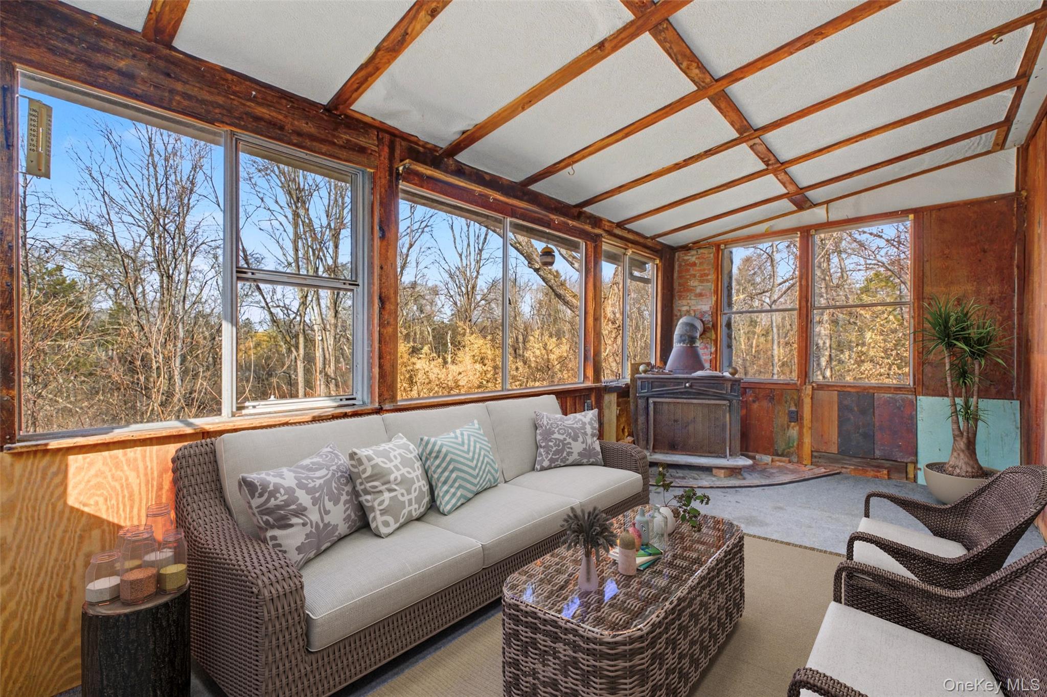 566 Old State Road Wappingers Falls, NY 12590 - Photo 12 of 19 Virtually Staged. Inviting sunroom offering abundant natural light and peaceful wooded views — an ideal space for relaxing or enjoying your morning coffee.