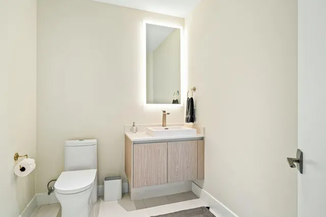 a bathroom with a toilet a sink and mirror