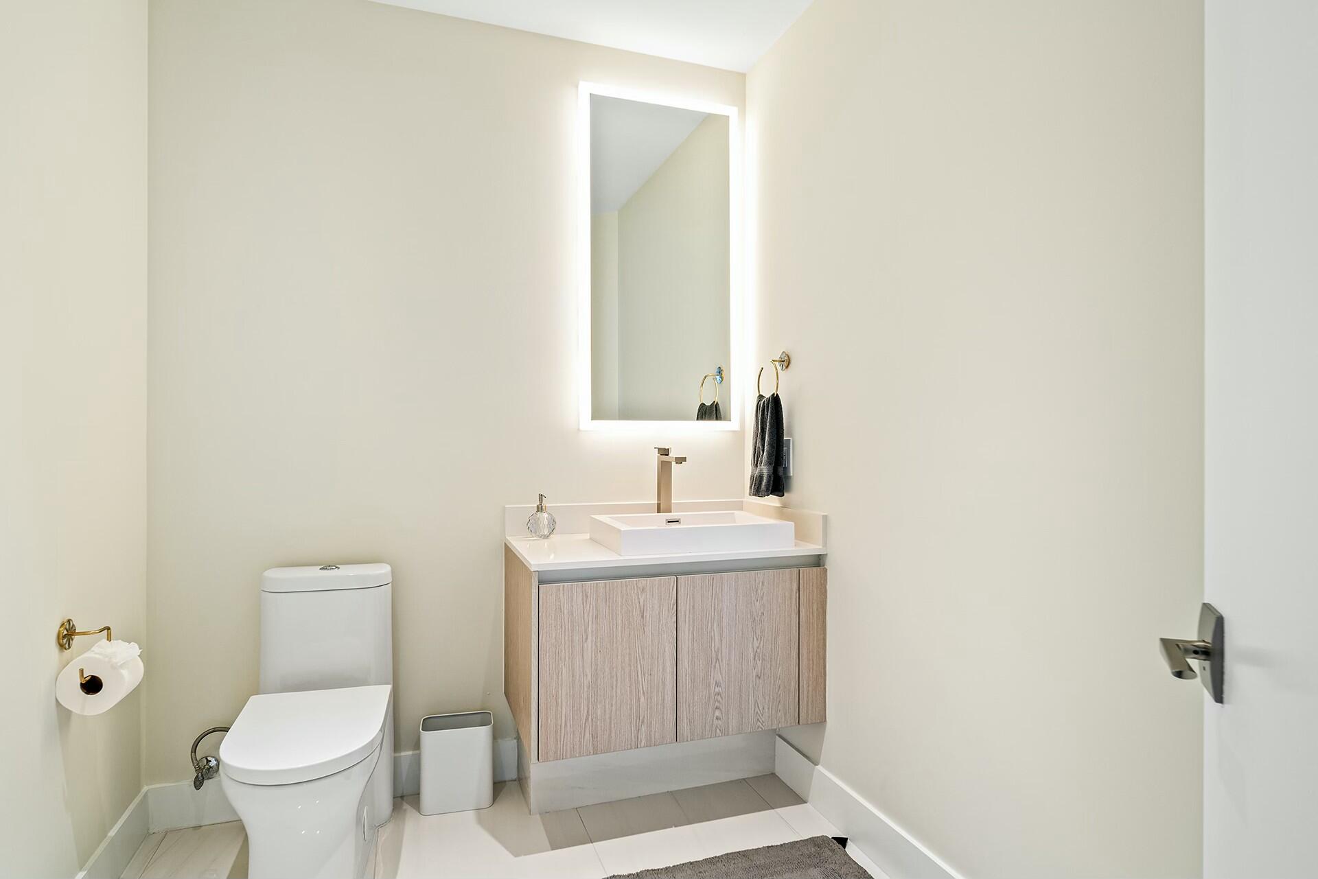 3100 North Ocean Drive, Unit H1409 Singer Island, FL 33404 - Photo 15 of 31 a bathroom with a toilet a sink and mirror