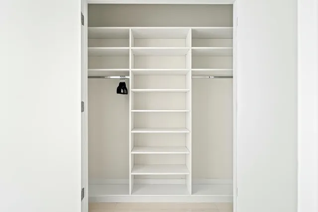 a view of a walk in closet with empty racks