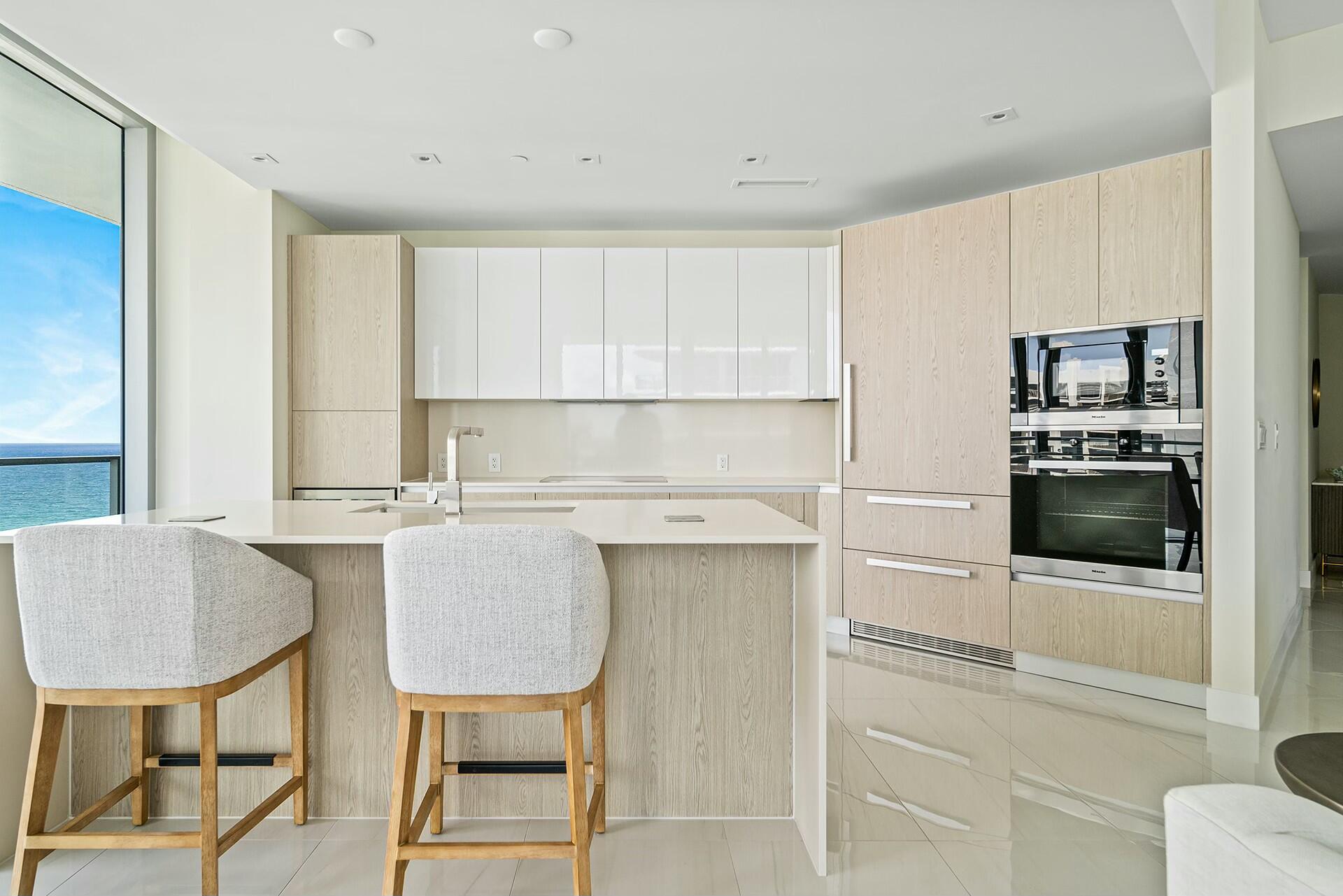 3100 North Ocean Drive, Unit H1409 Singer Island, FL 33404 - Photo 9 of 31 a kitchen with a table chairs refrigerator and cabinets