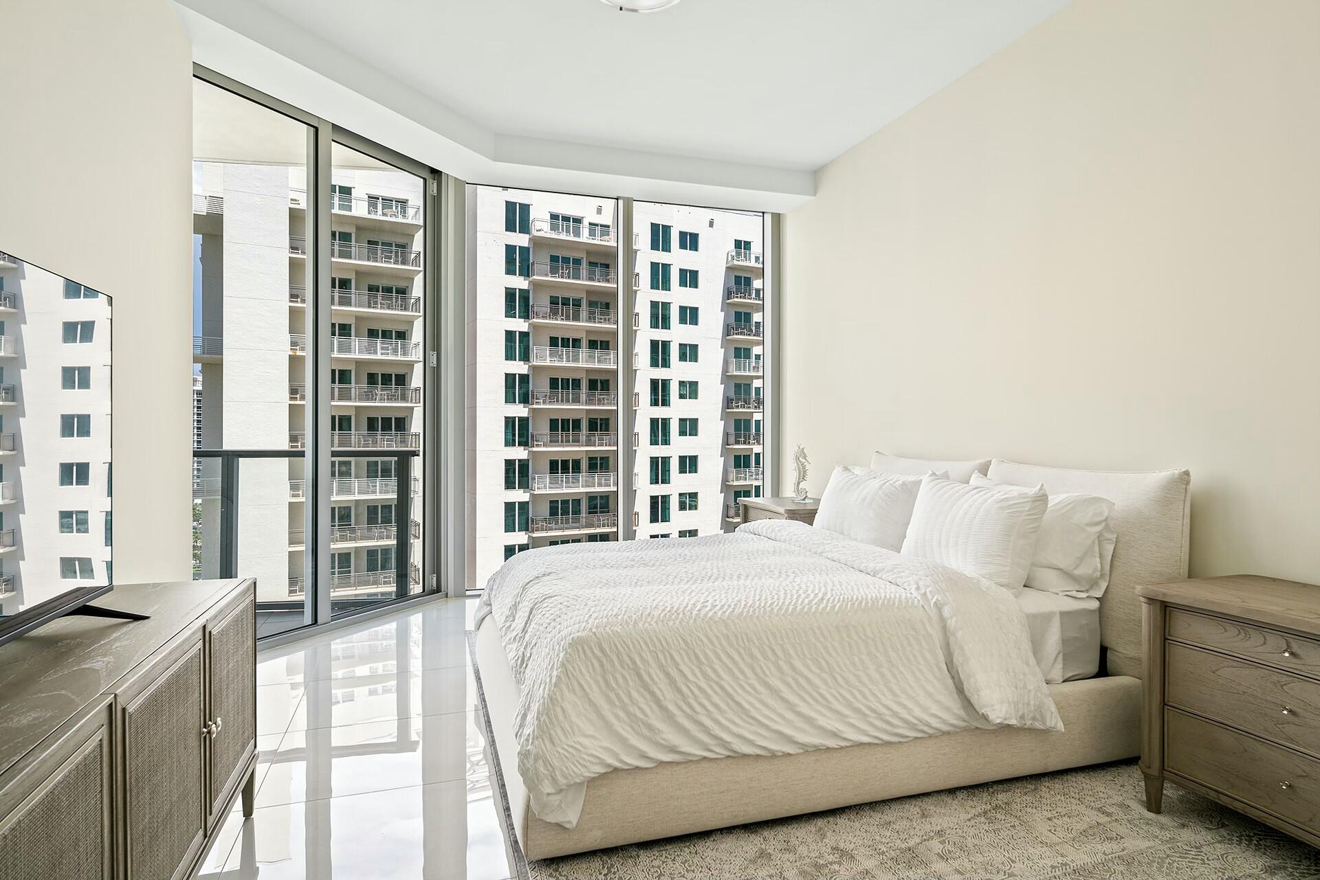 3100 North Ocean Drive, Unit H1409 Singer Island, FL 33404 - Photo 10 of 31 a bedroom with a large bed and a large window