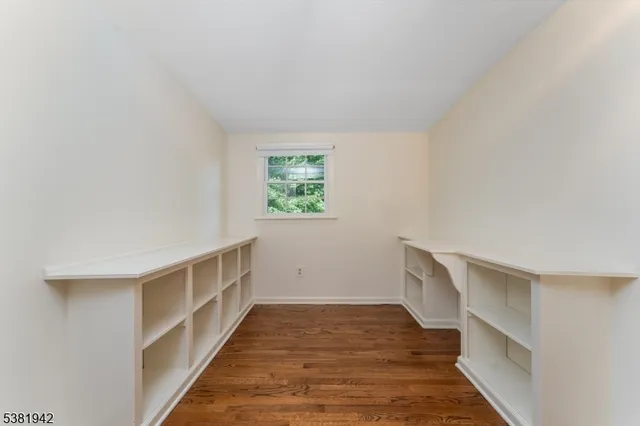 a view of hallway with wooden floor and cabinet