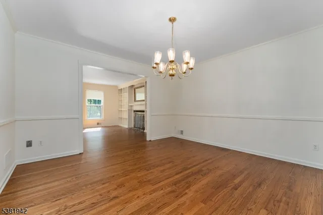 a view of a room with wooden floor chandelier and window