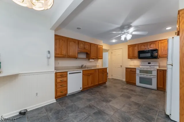 a kitchen with stainless steel appliances granite countertop a stove refrigerator sink and microwave