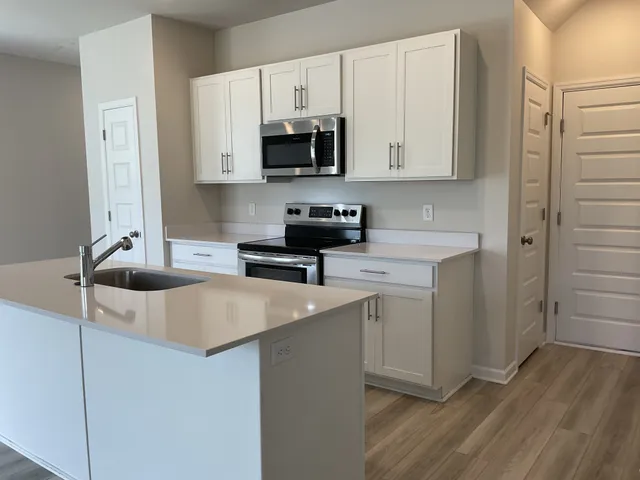 a kitchen with stainless steel appliances granite countertop a sink a stove and a refrigerator