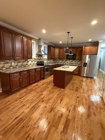 a large kitchen with kitchen island a stove a sink dishwasher and a oven