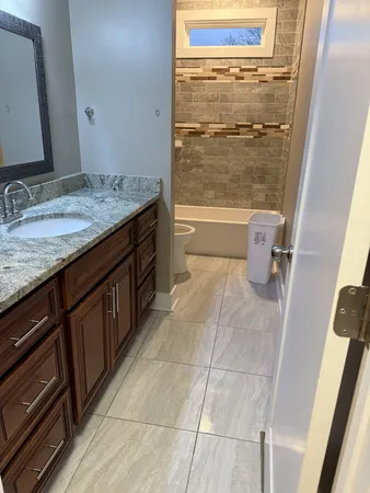 a bathroom with a granite countertop sink toilet and shower