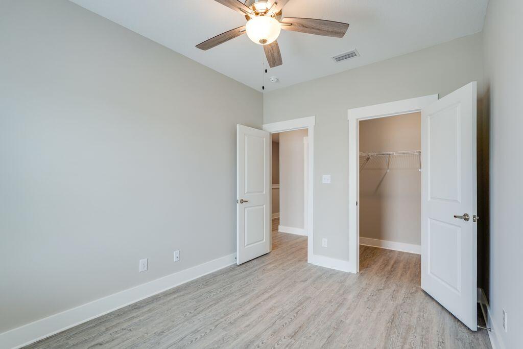 90 Date Palm Lane Freeport, FL 32439 - Photo 21 of 25 an empty room with wooden floor and ceiling fan