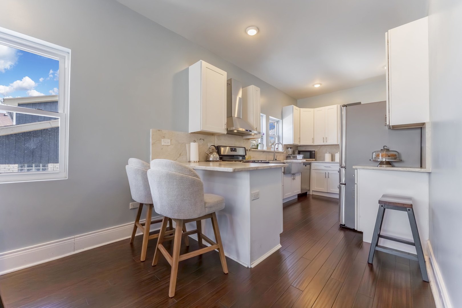 7731 45th Place Lyons, IL 60534 - Photo 5 of 21 a kitchen with stainless steel appliances a dining table chairs a sink dishwasher a refrigerator with wooden floor and cabinets