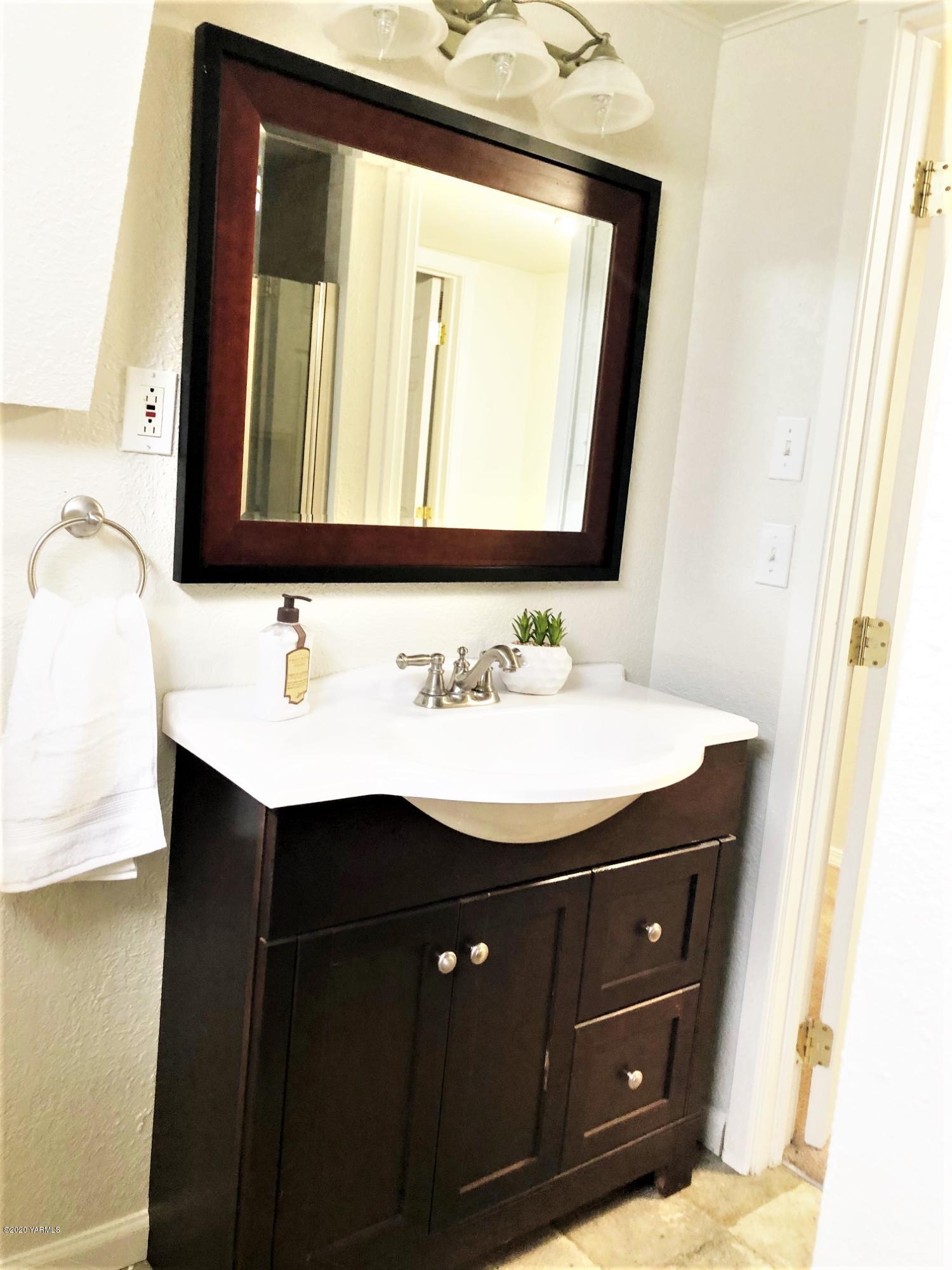 705 West Concord Avenue Grandview, WA 98930 - Photo 13 of 20 a bathroom with a sink vanity and a mirror