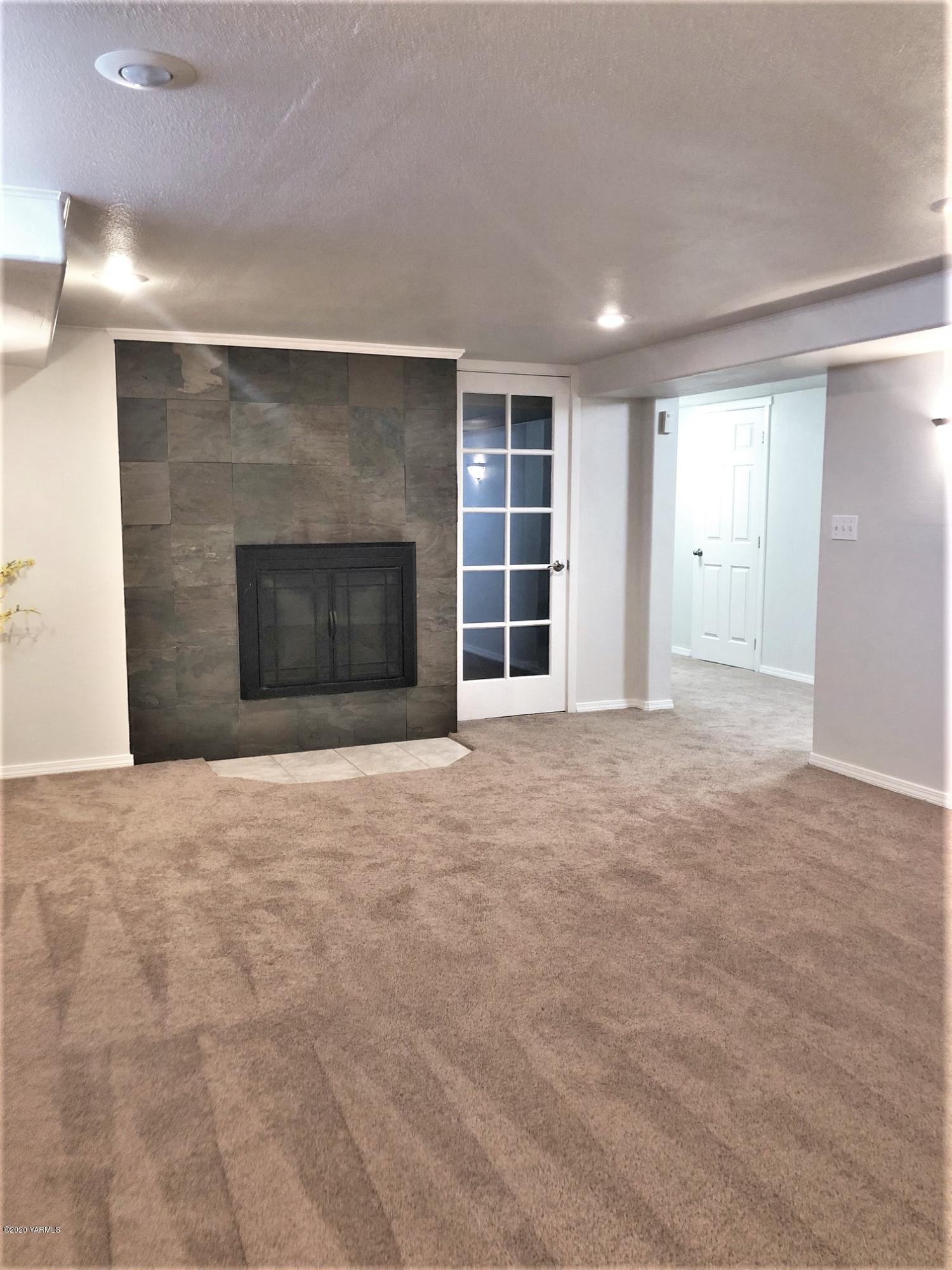 705 West Concord Avenue Grandview, WA 98930 - Photo 15 of 20 a view of an empty room with a fireplace and a window