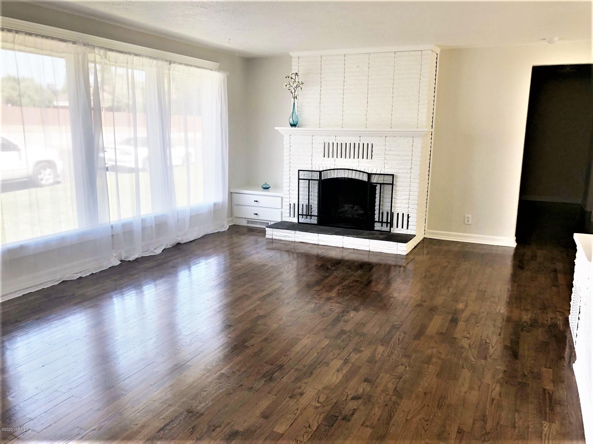 705 West Concord Avenue Grandview, WA 98930 - Photo 3 of 20 a view of an empty room with wooden floor and a window