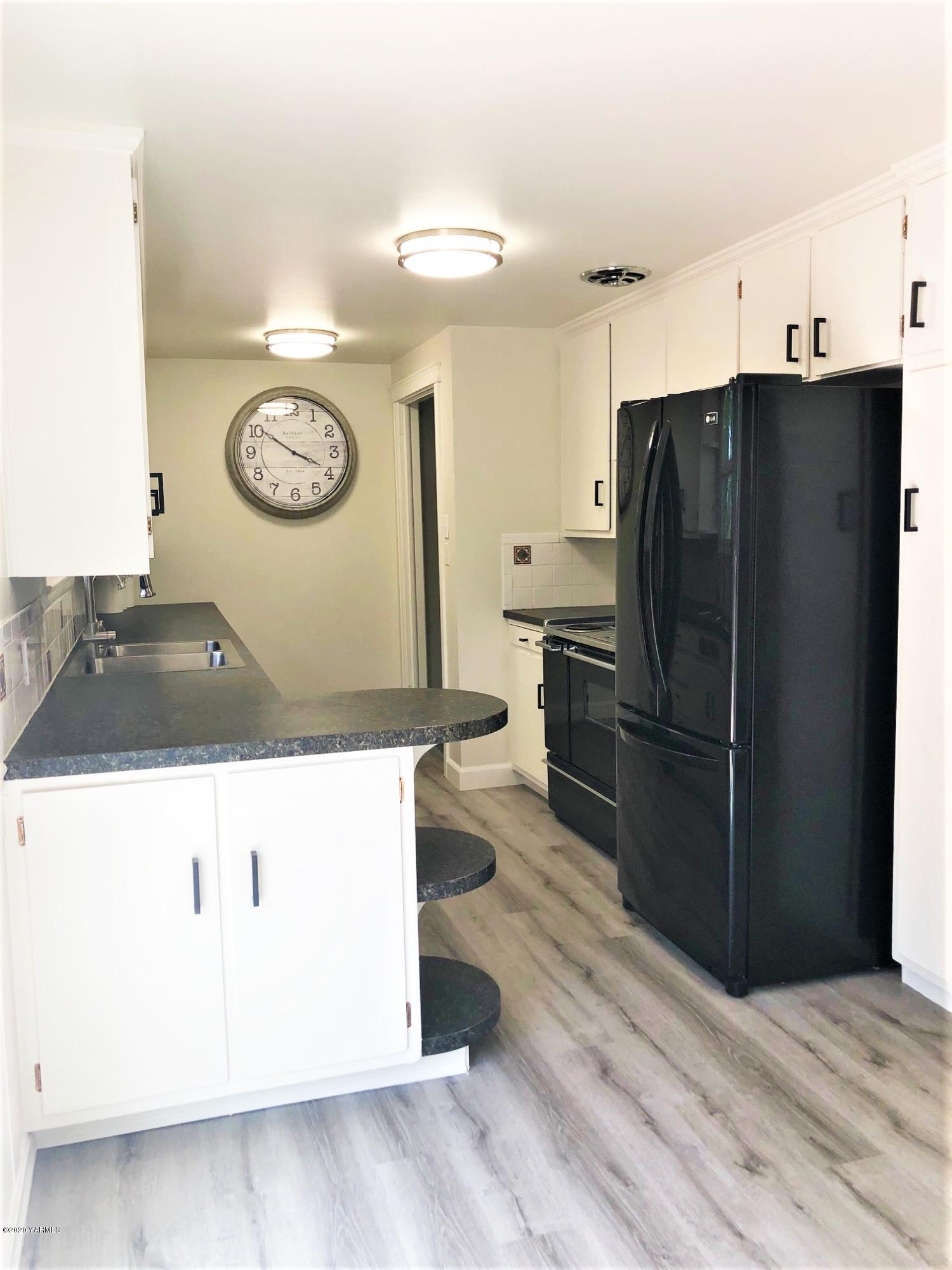 705 West Concord Avenue Grandview, WA 98930 - Photo 6 of 20 a kitchen with a refrigerator and a stove