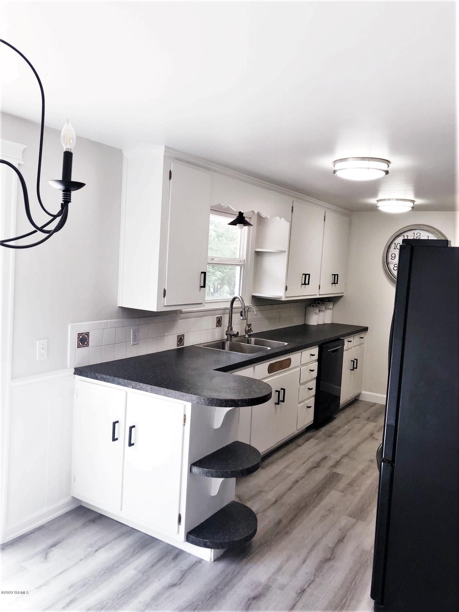 705 West Concord Avenue Grandview, WA 98930 - Photo 7 of 20 a kitchen with stainless steel appliances a sink a stove a refrigerator and cabinets