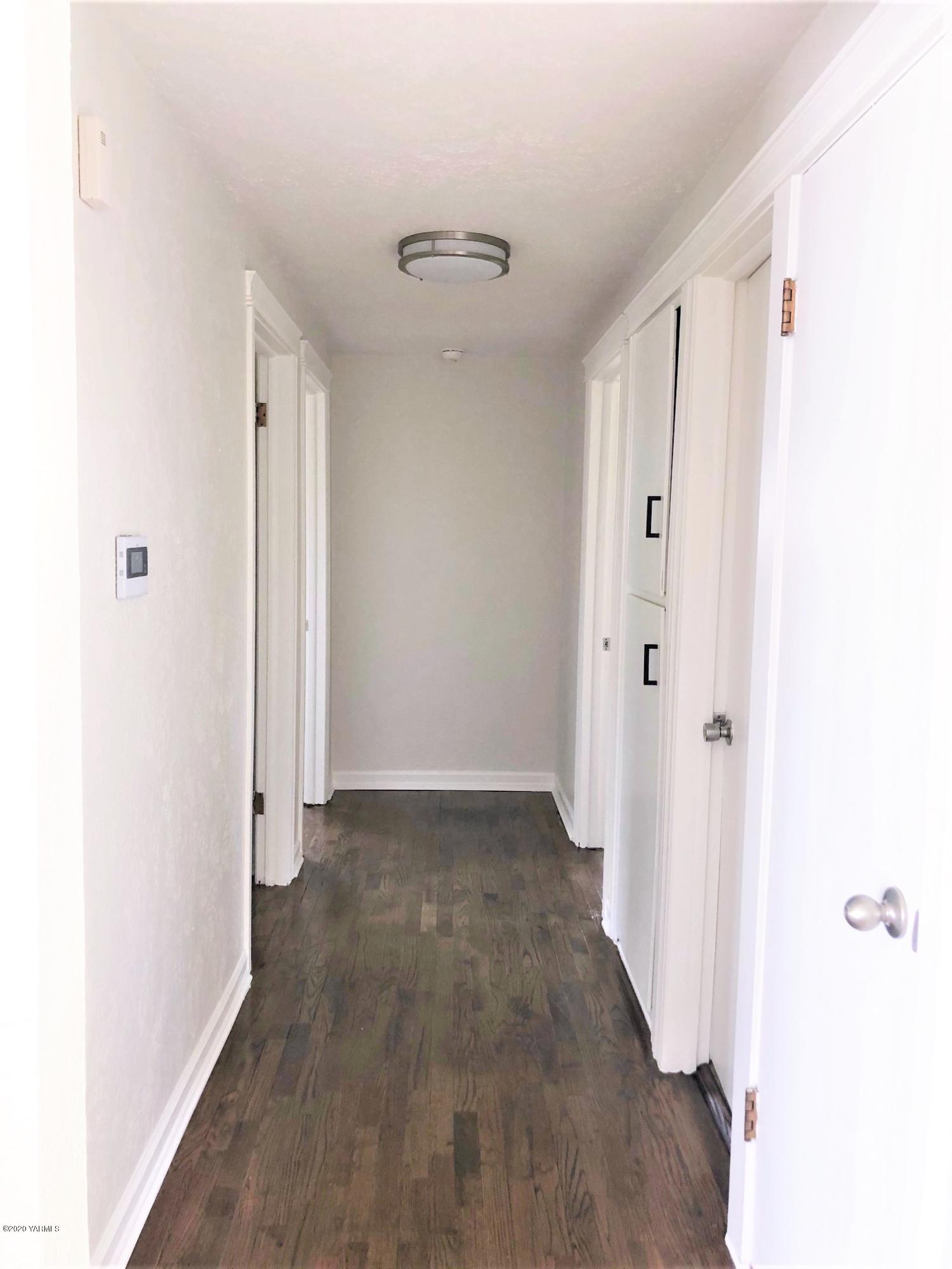 705 West Concord Avenue Grandview, WA 98930 - Photo 8 of 20 a view of a hallway with wooden floor