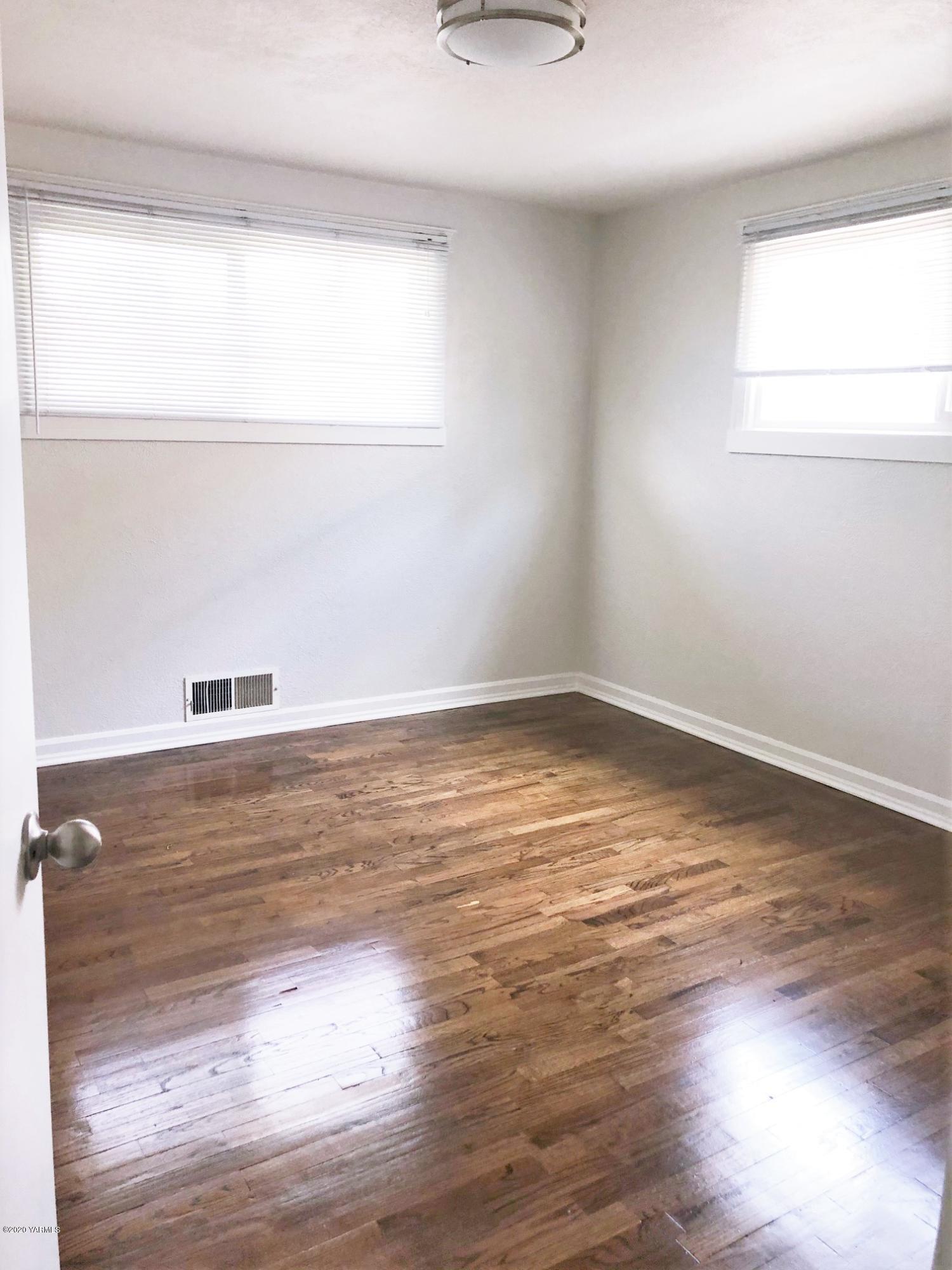705 West Concord Avenue Grandview, WA 98930 - Photo 9 of 20 a view of empty room with wooden floor and window