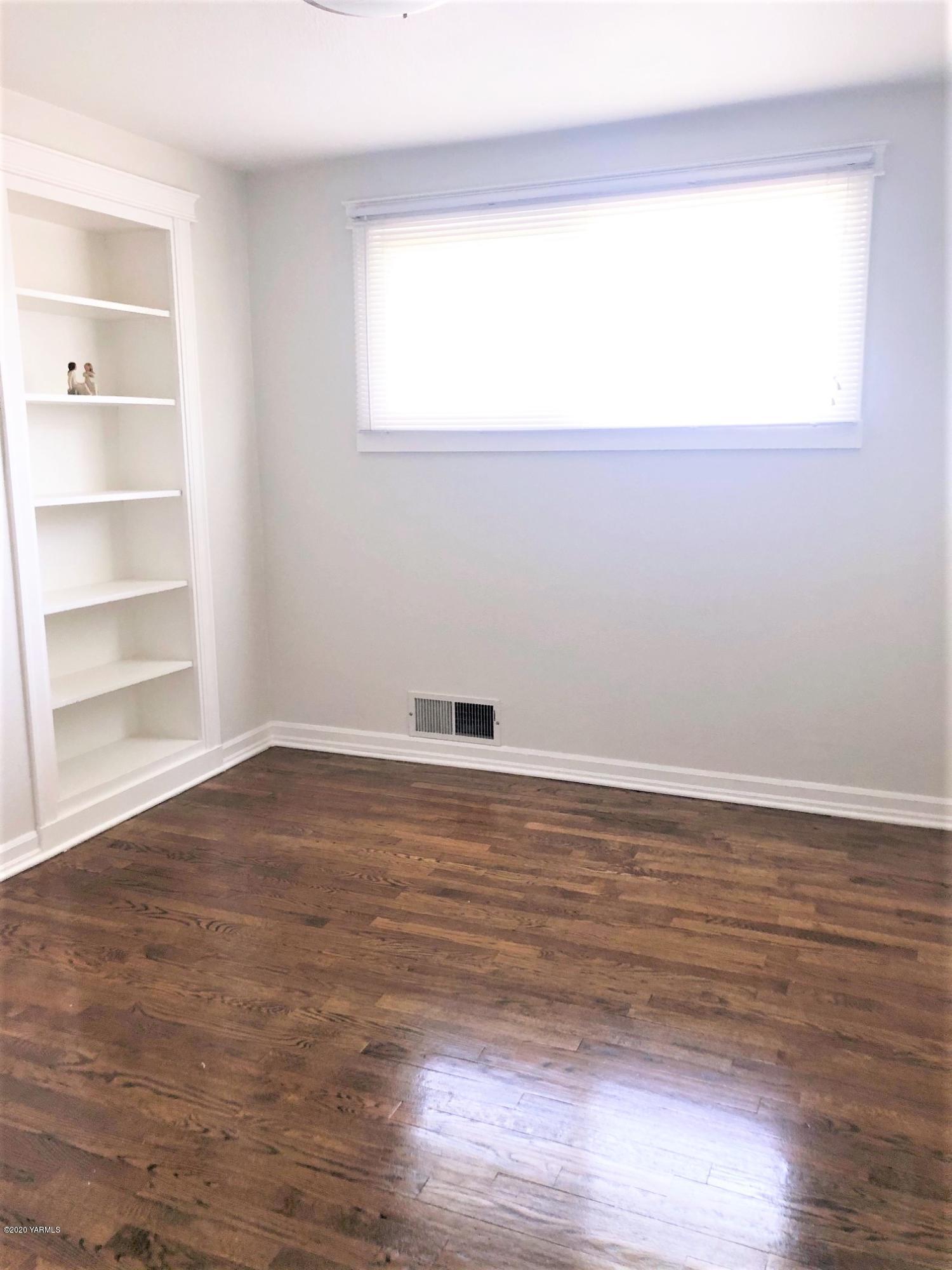 705 West Concord Avenue Grandview, WA 98930 - Photo 10 of 20 a view of an empty room with wooden floor and a window