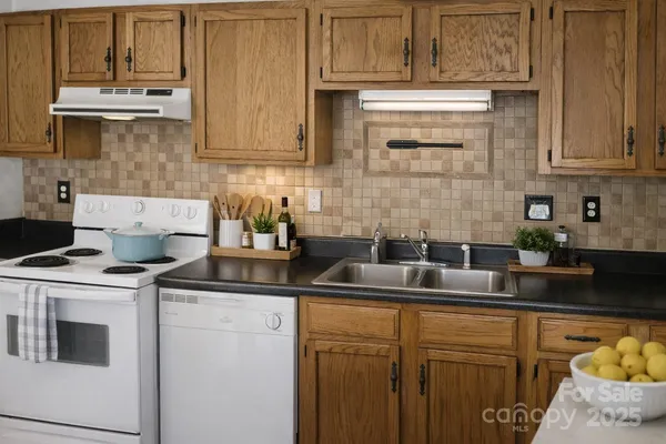 a kitchen with stainless steel appliances granite countertop a sink stove and cabinets