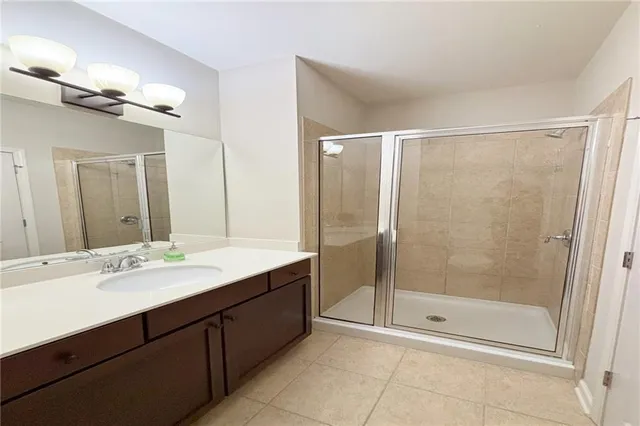 a bathroom with a shower sink vanity and mirror