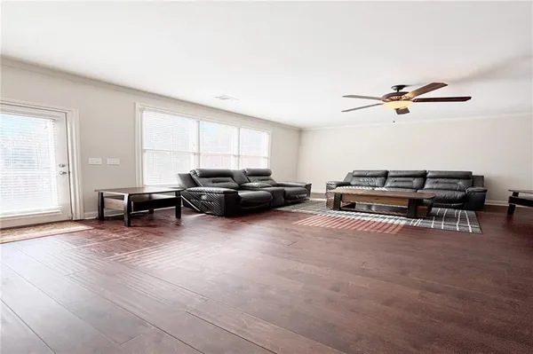 a living room with furniture a ceiling fan and a window