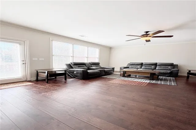 a living room with furniture a ceiling fan and a window