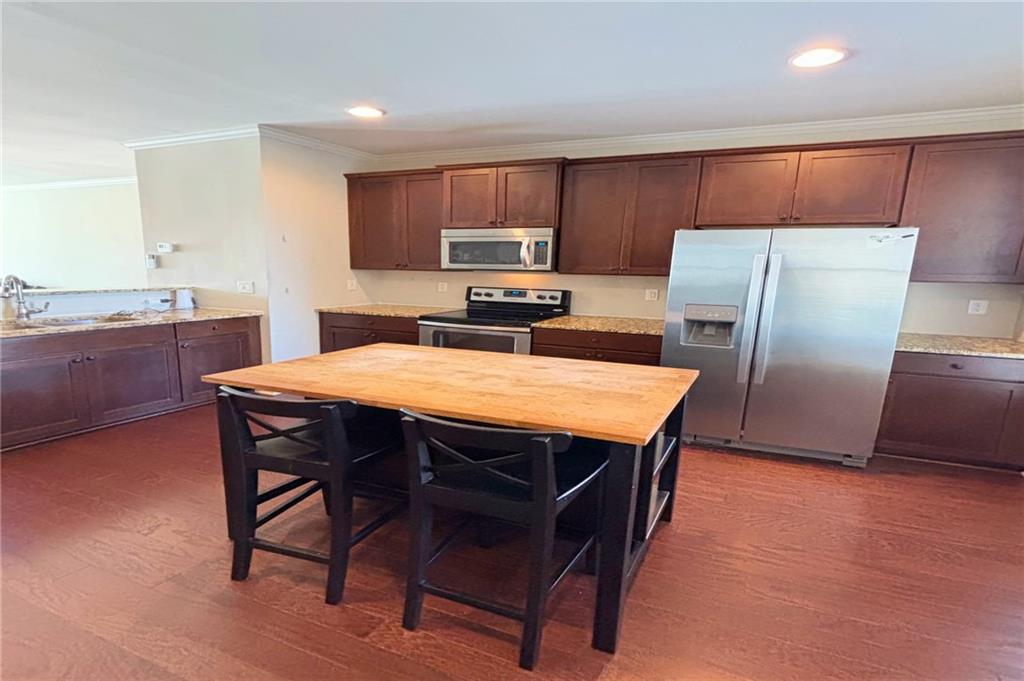 772 Liberty Commons Drive Northwest Atlanta, GA 30314 - Photo 9 of 23 a kitchen with stainless steel appliances a refrigerator a stove a sink a dining table and chairs