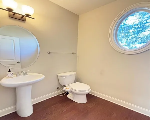 a bathroom with a toilet sink and mirror