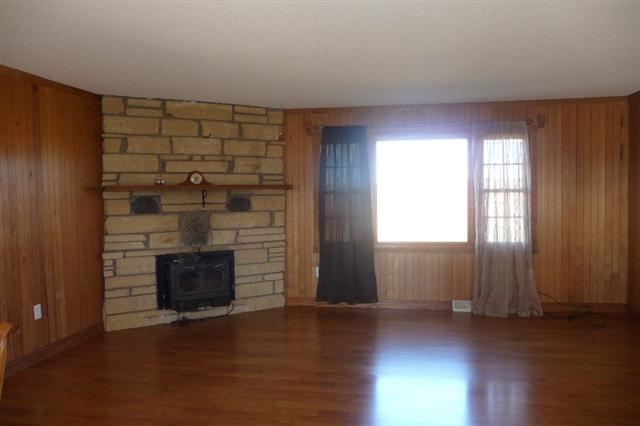28771 Crabtree Corner Road Cuba City, WI 53807 - Photo 3 of 12 an empty room with wooden floor fireplace and windows