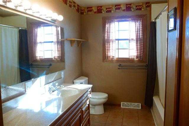 28771 Crabtree Corner Road Cuba City, WI 53807 - Photo 7 of 12 a bathroom with a granite countertop toilet a sink and a window
