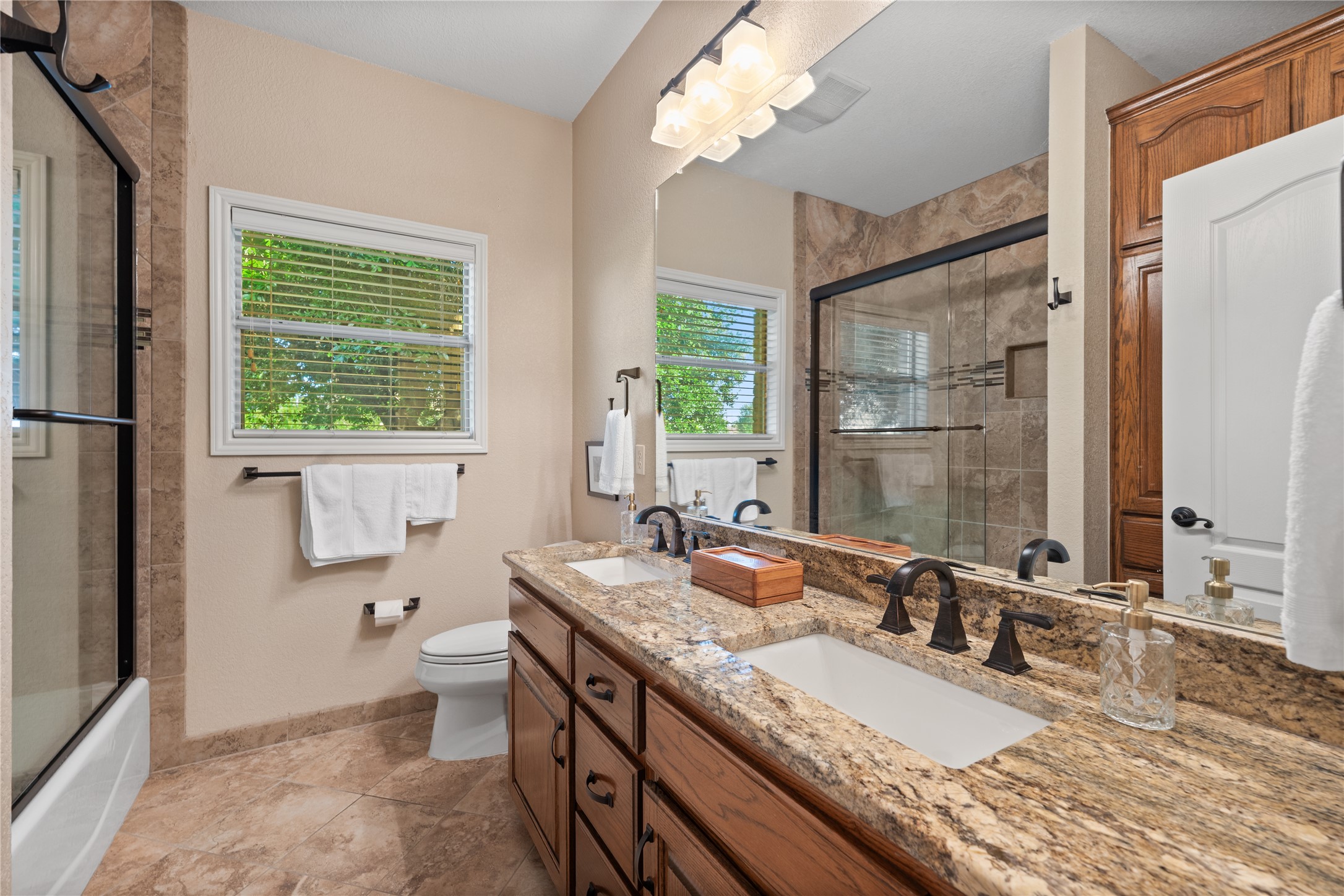 266 Courtnee's Way Georgetown, TX 78626 - Photo 22 of 40 Bathroom featuring a dual vanity with a granite countertop and tile to the ceiling shower/tub combo.
