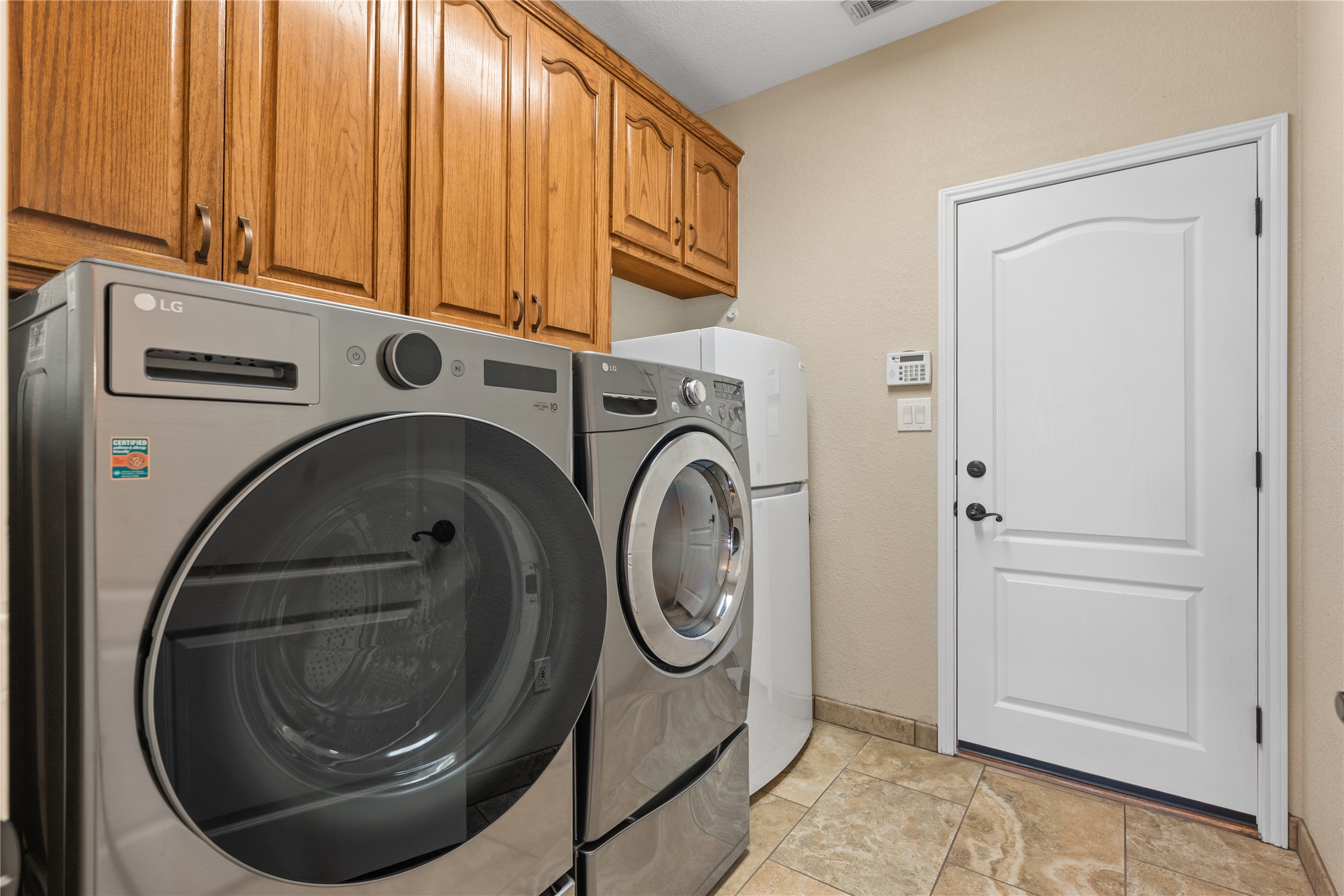266 Courtnee's Way Georgetown, TX 78626 - Photo 24 of 40 Laundry room featuring custom cabinetry, tiled flooring, and room for a second refrigerator.