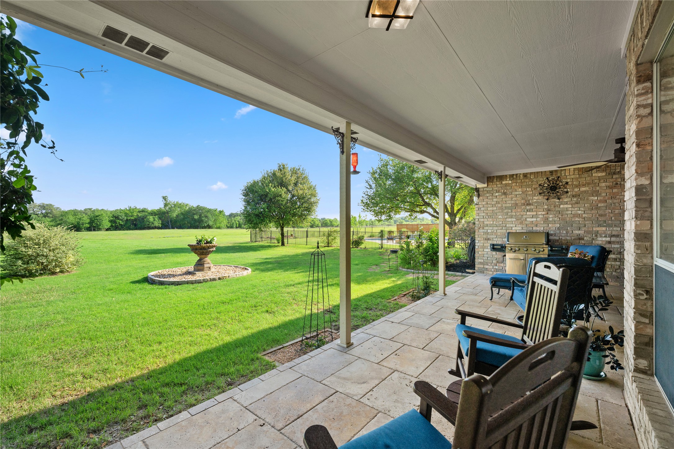 266 Courtnee's Way Georgetown, TX 78626 - Photo 26 of 40 Peaceful setting from this spacious covered patio featuring large Travertine paver flooring and a brick exterior