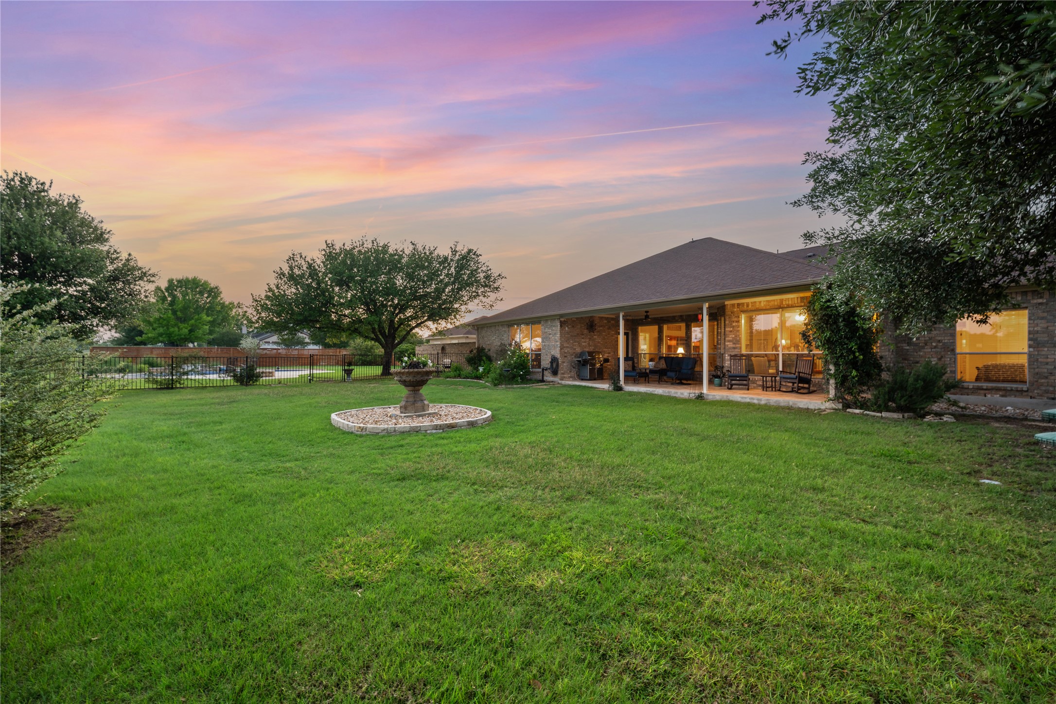 266 Courtnee's Way Georgetown, TX 78626 - Photo 27 of 40 Expansive lawn with mature trees and a wrought iron fence.