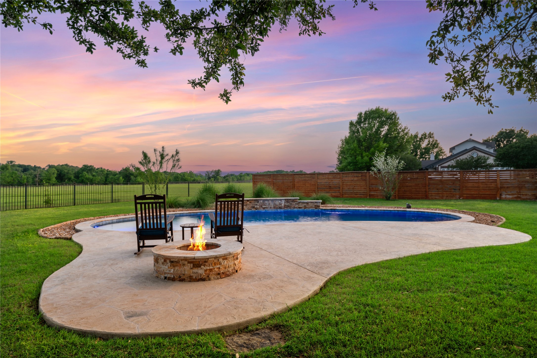 266 Courtnee's Way Georgetown, TX 78626 - Photo 33 of 40 Backyard oasis featuring a freeform swimming pool, a stone-clad fire pit and privacy/wrought iron fencing.