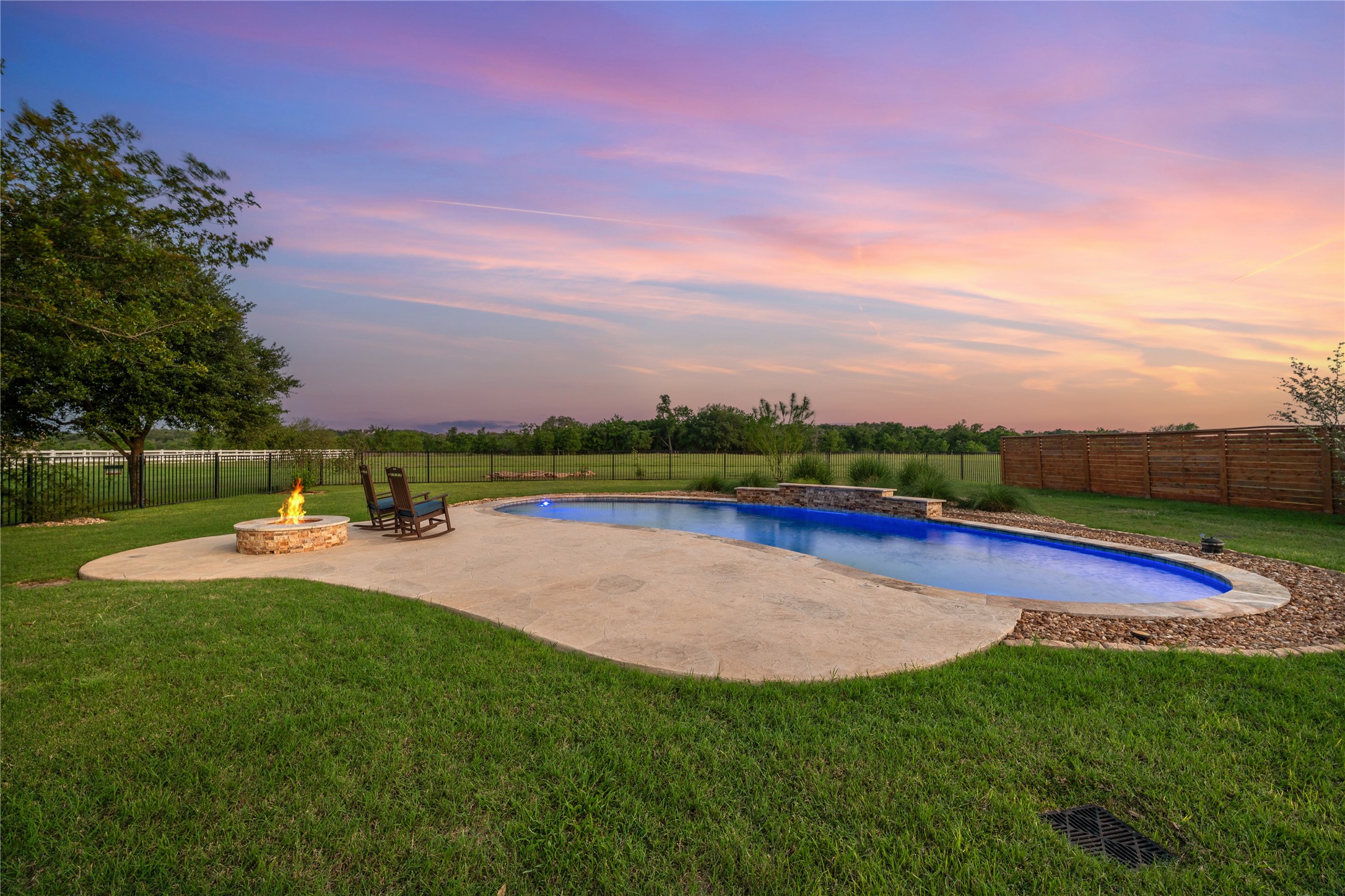 266 Courtnee's Way Georgetown, TX 78626 - Photo 34 of 40 Private backyard featuring a custom swimming pool with concrete decking, a stone fire pit, and a waterfall.