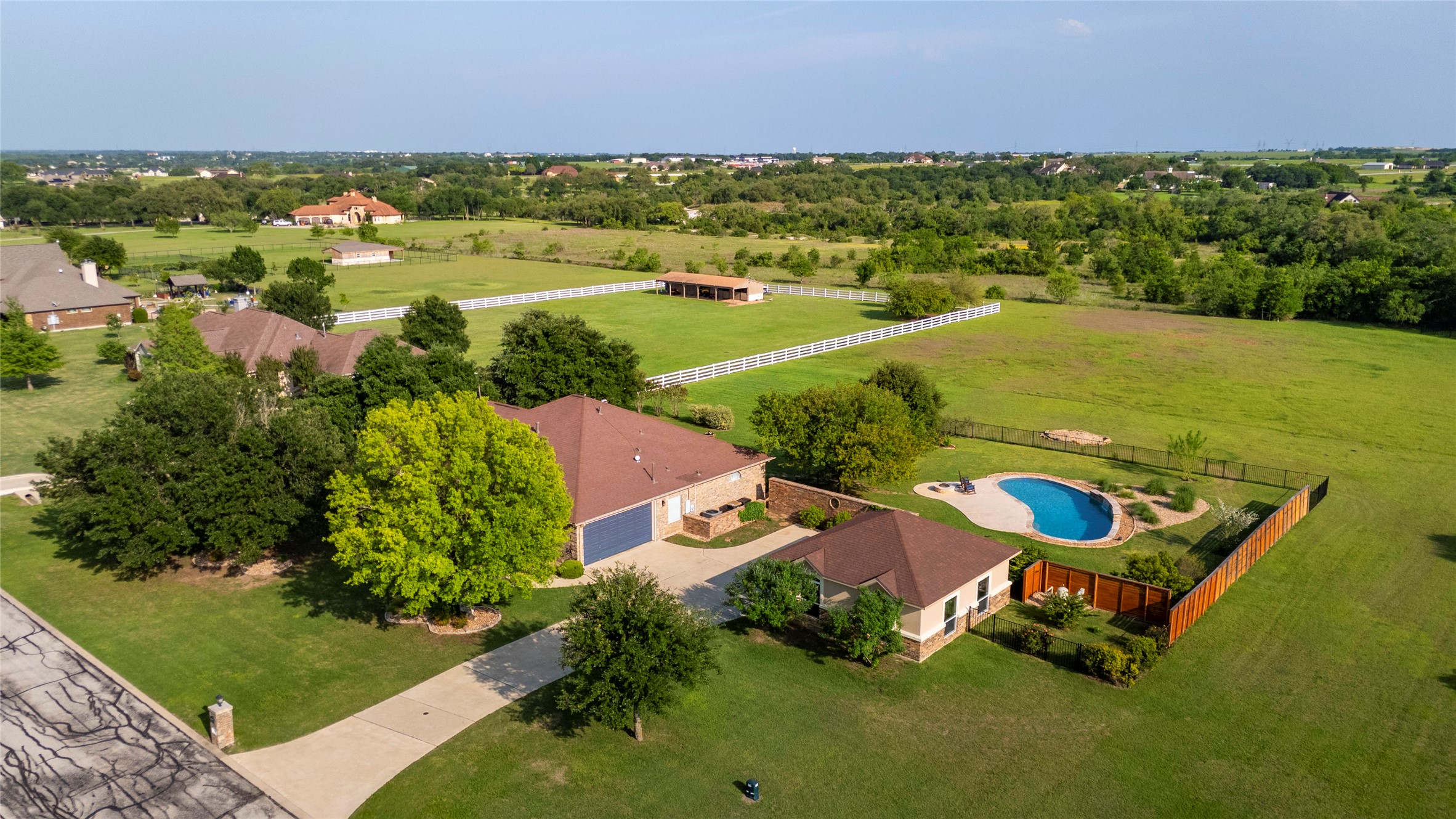 266 Courtnee's Way Georgetown, TX 78626 - Photo 39 of 40 Expansive property featuring a curved swimming pool, a privacy fence and detached garage matching the exterior of the home.