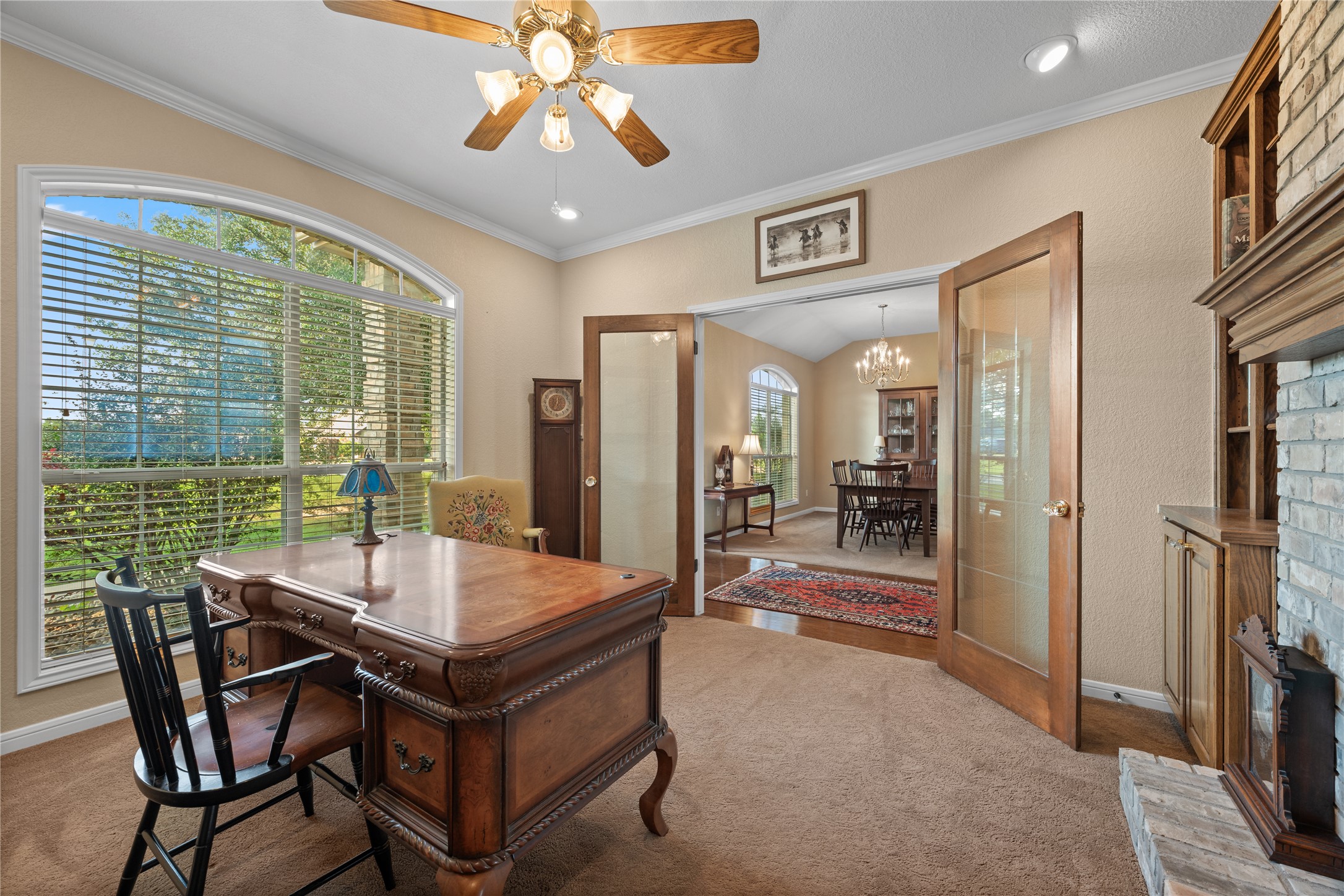 266 Courtnee's Way Georgetown, TX 78626 - Photo 9 of 40 Arched window with exterior tree views, French doors, built-in shelving, fireplace with brick surround, and recessed lighting