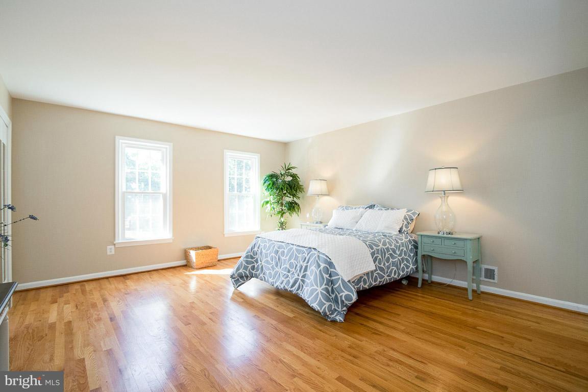 10802 Hunt Club Road Reston, VA 20190 - Photo 19 of 30 a spacious bedroom with a bed and wooden floor