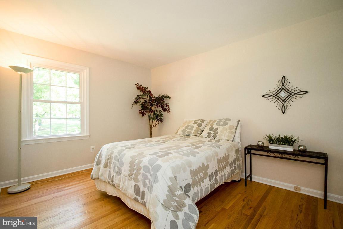 10802 Hunt Club Road Reston, VA 20190 - Photo 26 of 30 a bedroom with a bed and wooden floor