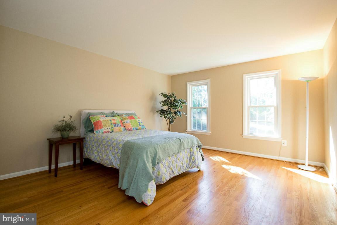 10802 Hunt Club Road Reston, VA 20190 - Photo 27 of 30 a bedroom with a bed and wooden floor