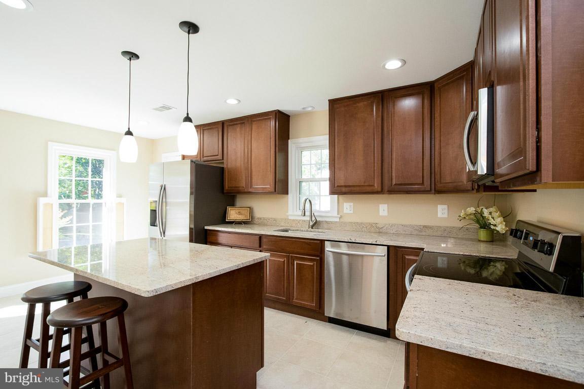 10802 Hunt Club Road Reston, VA 20190 - Photo 7 of 30 a kitchen with stainless steel appliances granite countertop a sink a stove and a refrigerator