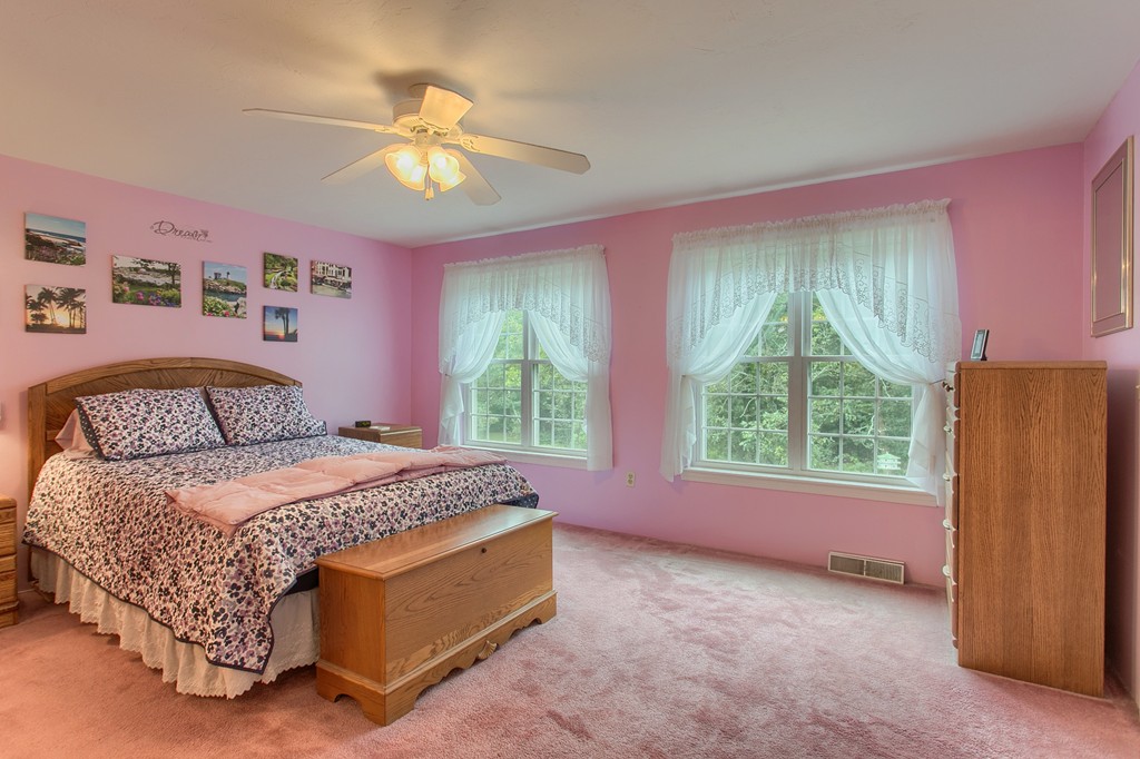 914 Ridgefield Circle, Unit B Clinton, MA 01510 - Photo 18 of 30 a spacious bedroom with a bed and a chandelier