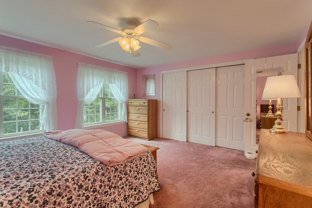 914 Ridgefield Circle, Unit B Clinton, MA 01510 - Photo 19 of 30 a spacious bedroom with a bed and a chandelier