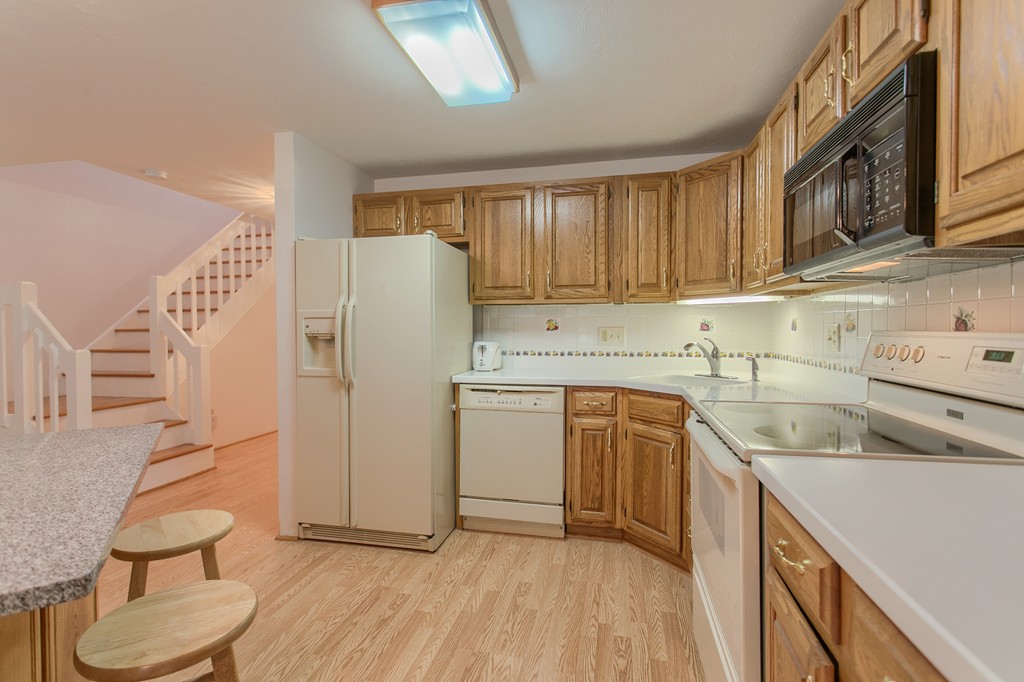 914 Ridgefield Circle, Unit B Clinton, MA 01510 - Photo 5 of 30 a kitchen with a sink a stove a refrigerator and cabinets