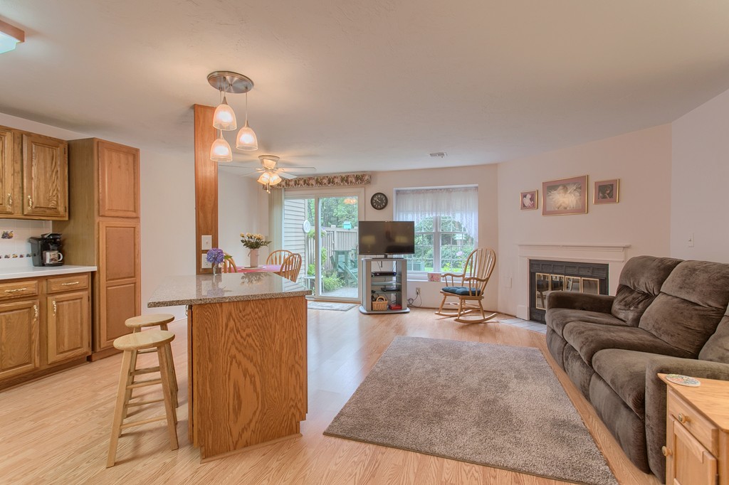 914 Ridgefield Circle, Unit B Clinton, MA 01510 - Photo 9 of 30 a living room with furniture a fireplace and a kitchen view