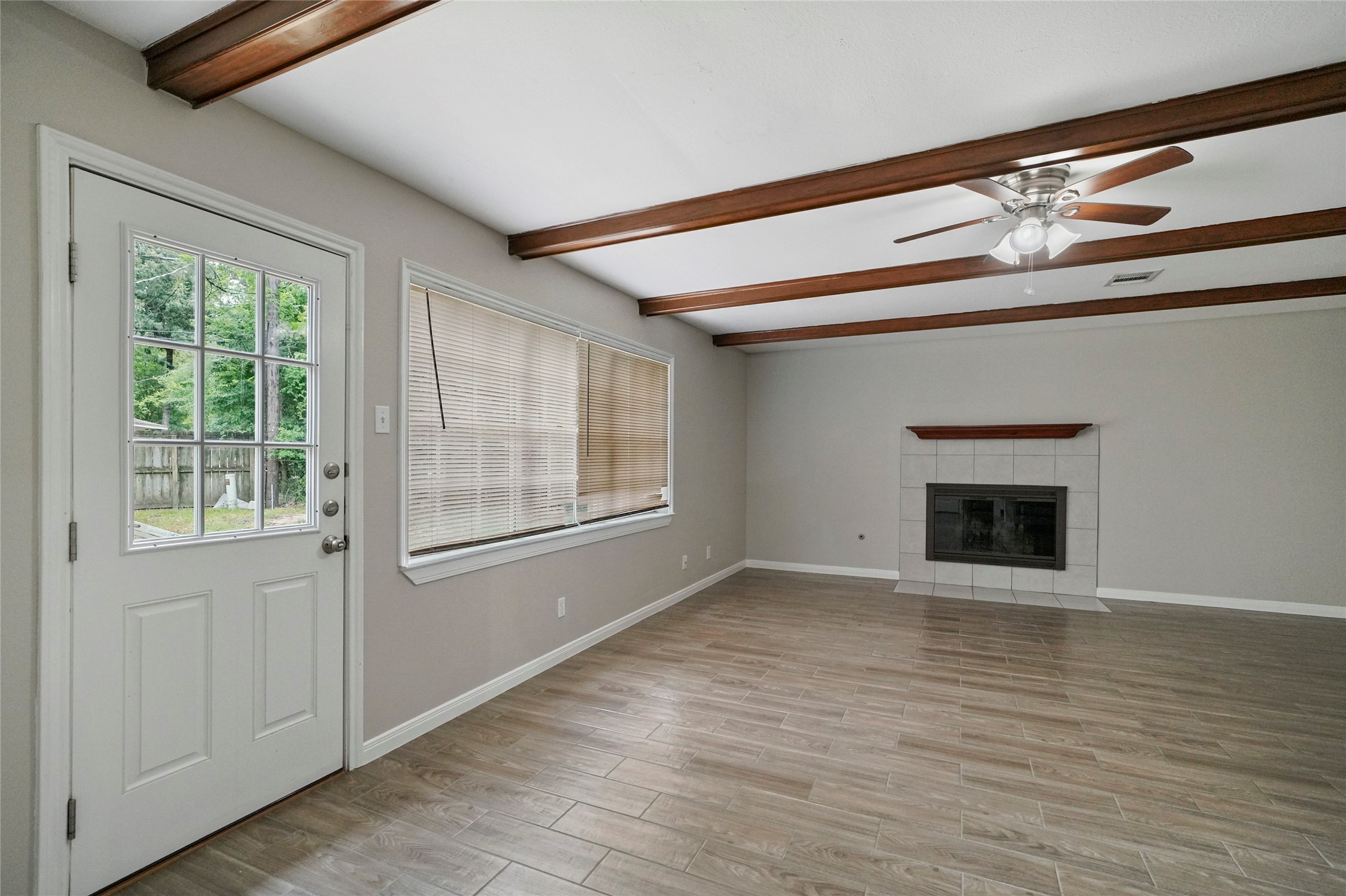 643 Ames Street Spring, TX 77373 - Photo 17 of 32 an empty room with wooden floor fireplace and windows